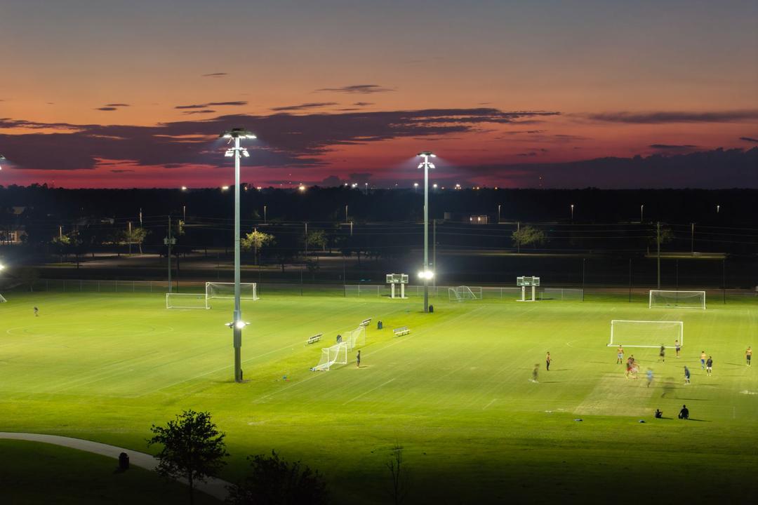 Amateur football on floodlit grass pitches at dusk