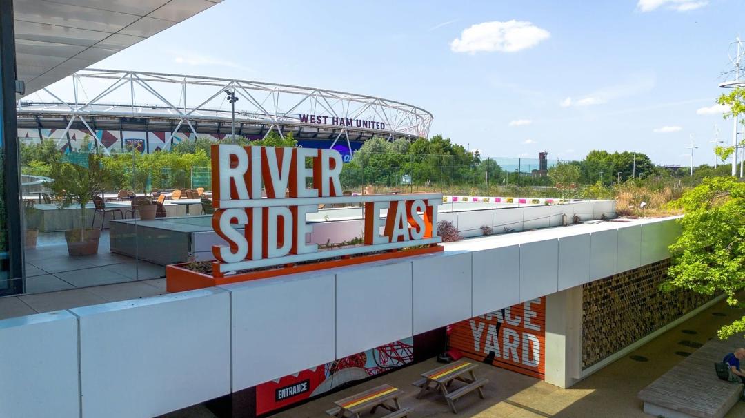 The Riverside East sign by the London Stadium in Queen Elizabeth Olympic Park, on a sunny day.